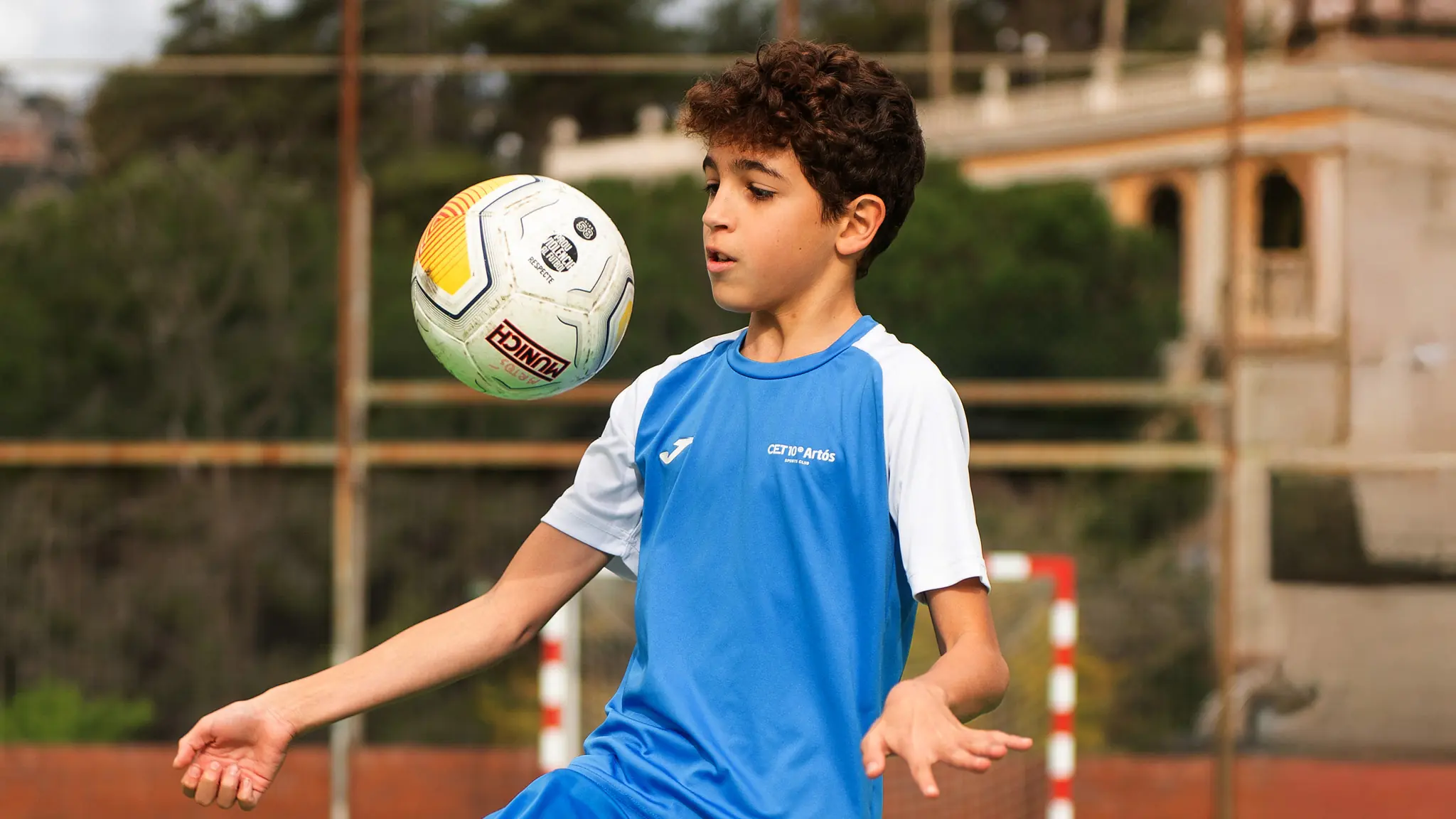 nen amb equipació blava jugant a futbol escola de futbol sala artos sports club